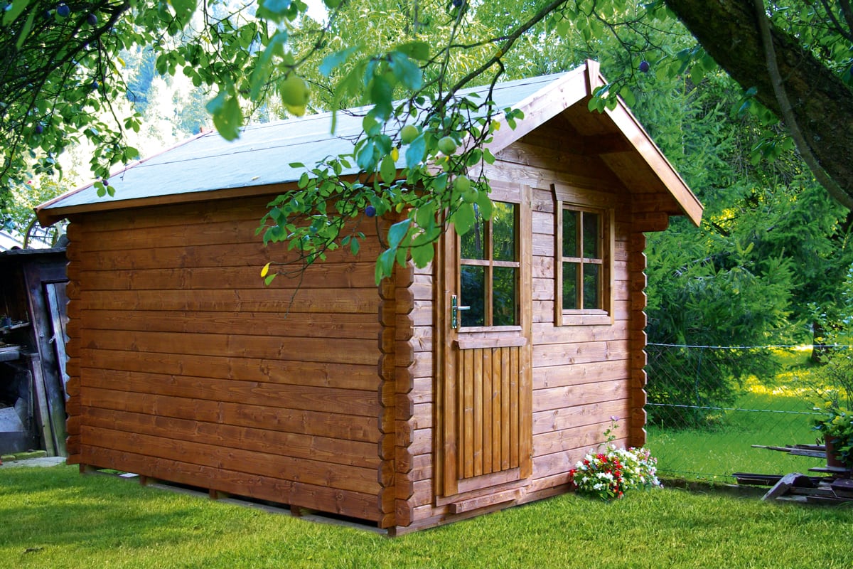 Holz-Gartenhaus mit Tür und zwei Fenstern, umgeben von grünem Gras und Bäumen