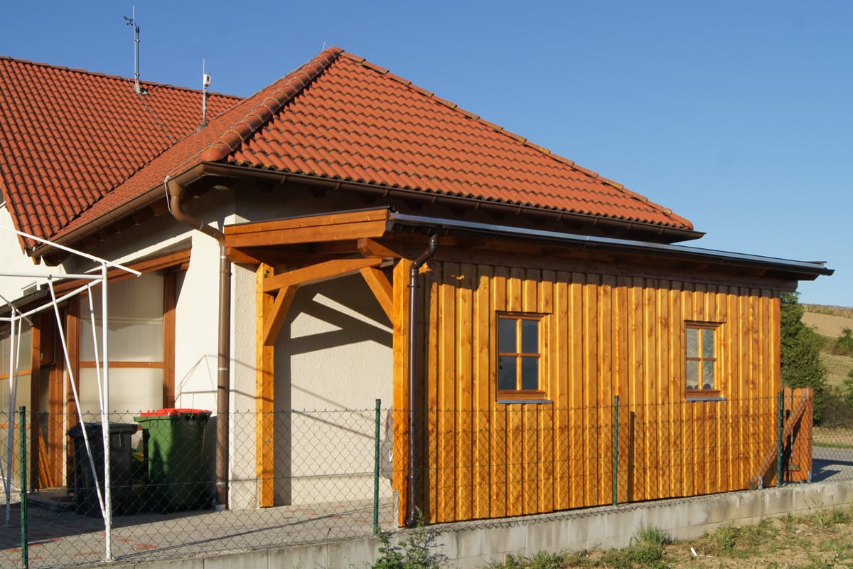 Pultdachcarports als Wandanbau mit einer geschlossenen Seitenwand aus Deckelschalung
