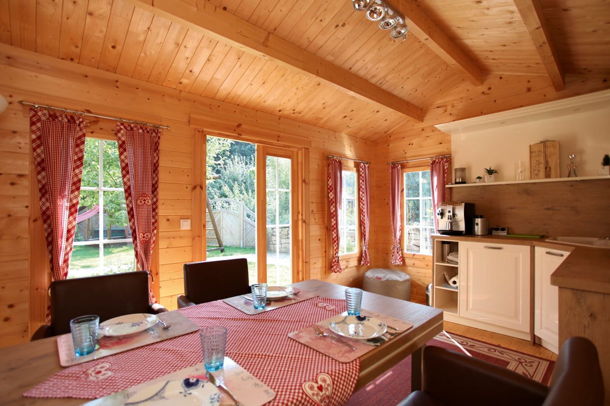 Innenraum eines Gartenhauses aus Holz mit gedecktem Tisch