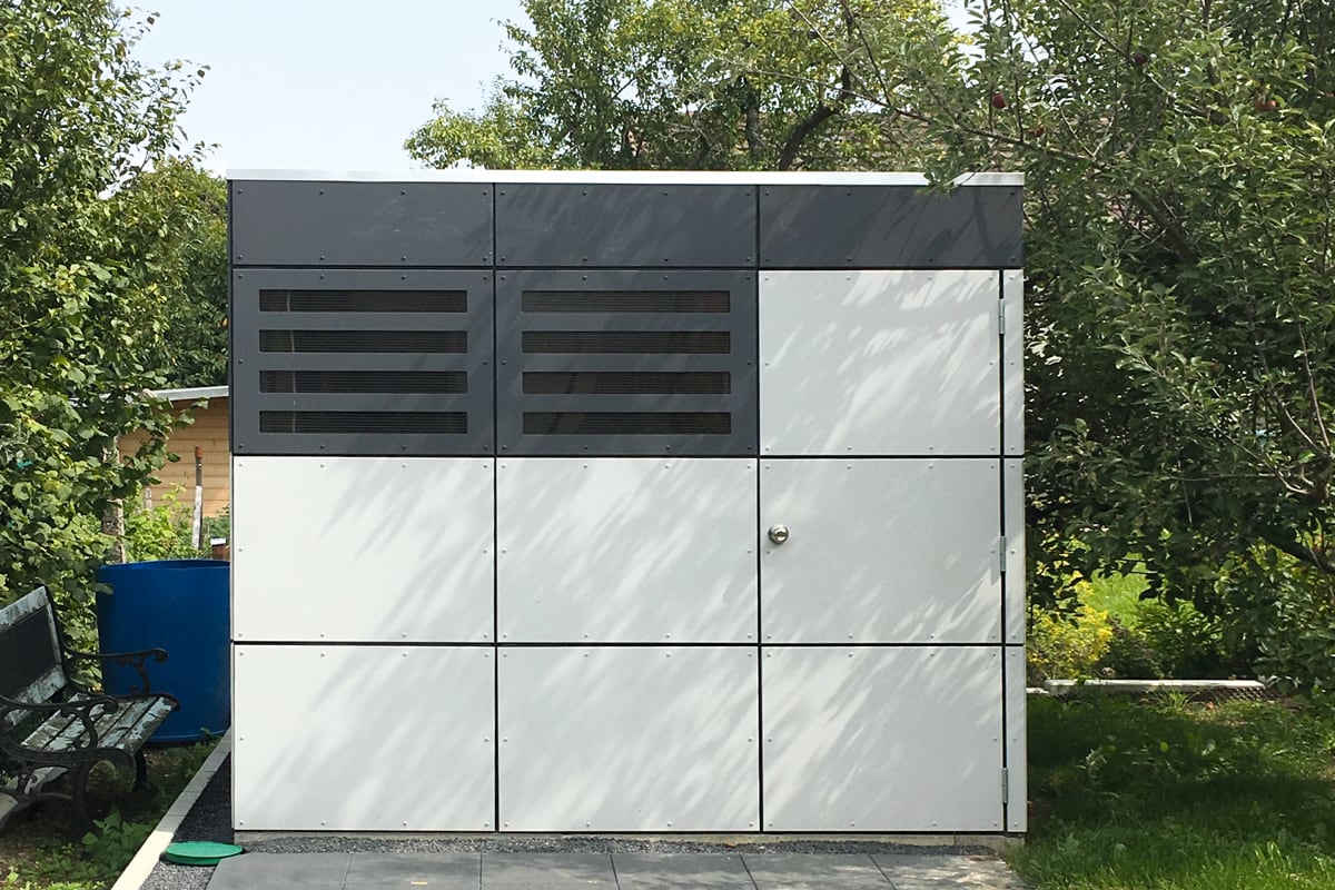 Modernes graues Gerätehaus CrossCube in Würfelform auf Rasen