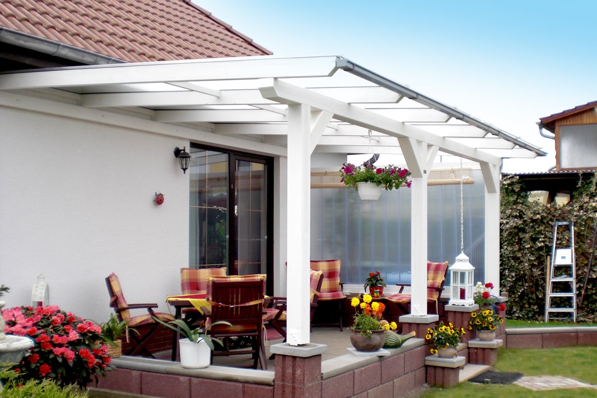 Eine stabile weiße Holzüberdachung mit klaren Linien verleiht der Terrasse ein helles, modernes Ambiente. Sie bietet einen geschützten Raum zum Verweilen und verbindet Funktionalität mit Eleganz.