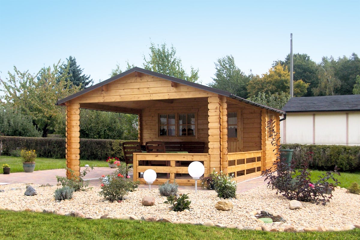 Holzhaus Alicante mit überdachter Veranda in einem Garten mit Kiesbeet und Blumen