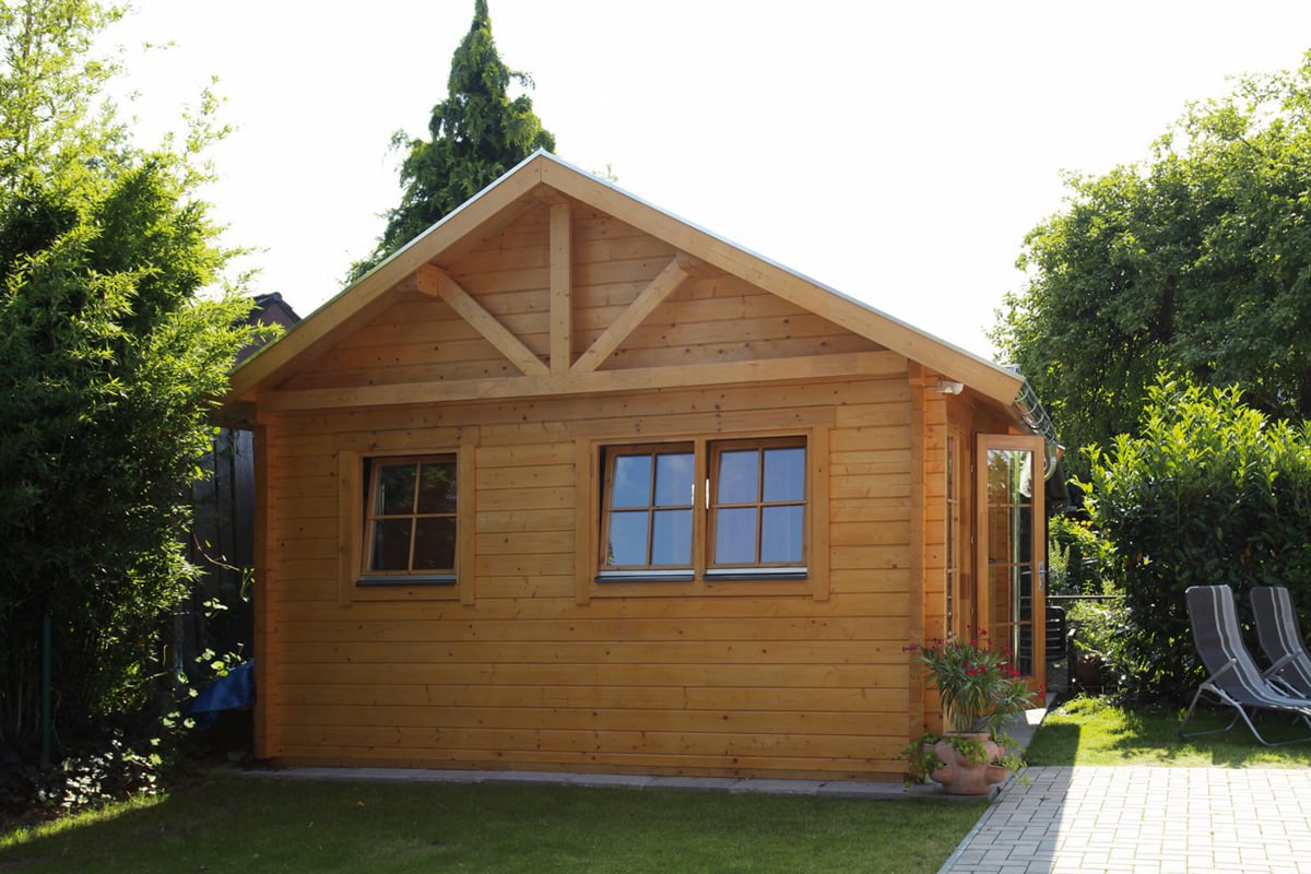 Freizeithaus aus Holz mit Liegenstühlen an der Seite