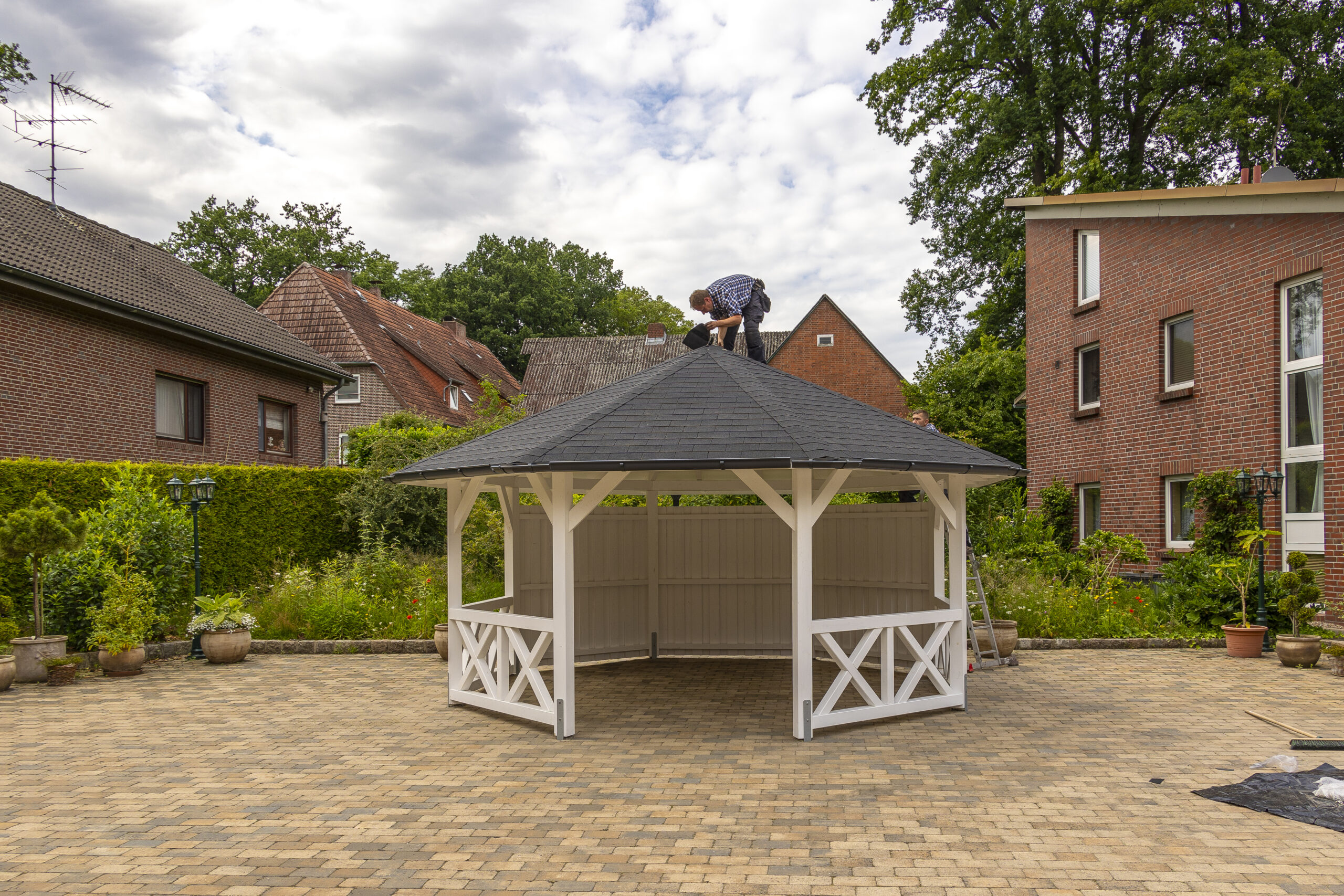 Monteur auf dem Dach eines Pavillons