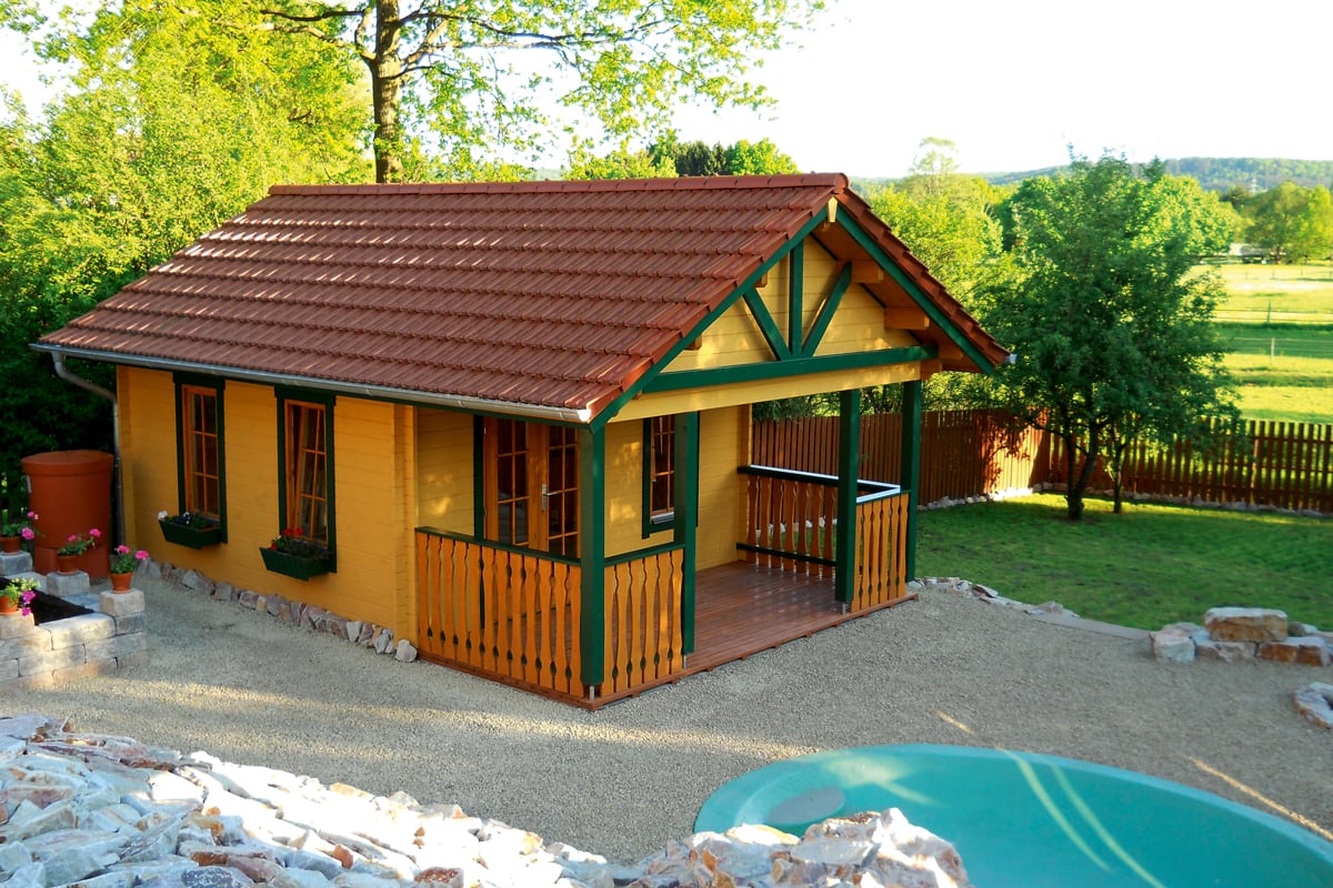 Buntes Gartenhaus aus Holz mit Dachpfannen mit Pool davor