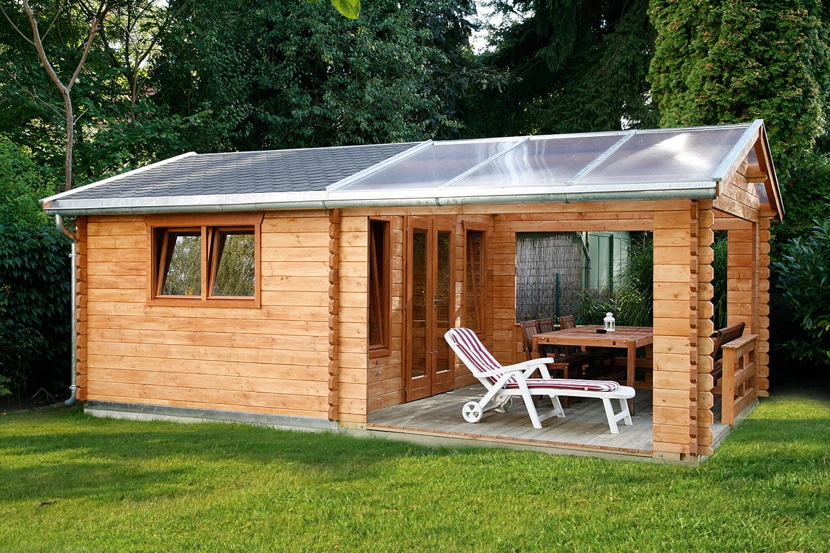 Holzhaus Holmestrand mit verglaster Terrasse, Liegestuhl und Gartentisch mit Stühlen im Garten