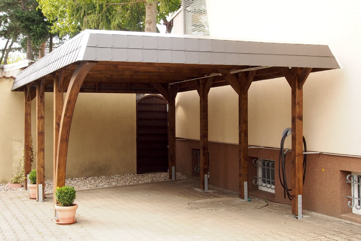 ChatGPT: Moderner Holz-Carport mit elegantem Walmdach, stabilem Unterbau und wetterfester Lasur – idealer Schutz für Ihr Fahrzeug direkt am Haus.