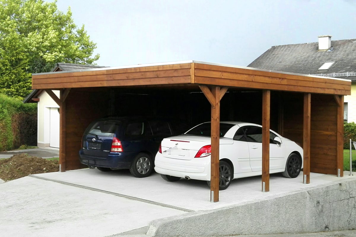 Geräumiger Doppelcarport aus robustem Holz mit Flachdach und Seitenwand – bietet zwei Fahrzeugen optimalen Schutz vor Wind und Wetter.