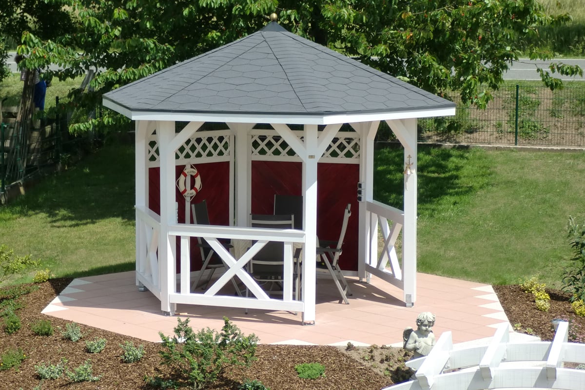 Weißer Holzpavillon mit Brüstungen in einem Garten