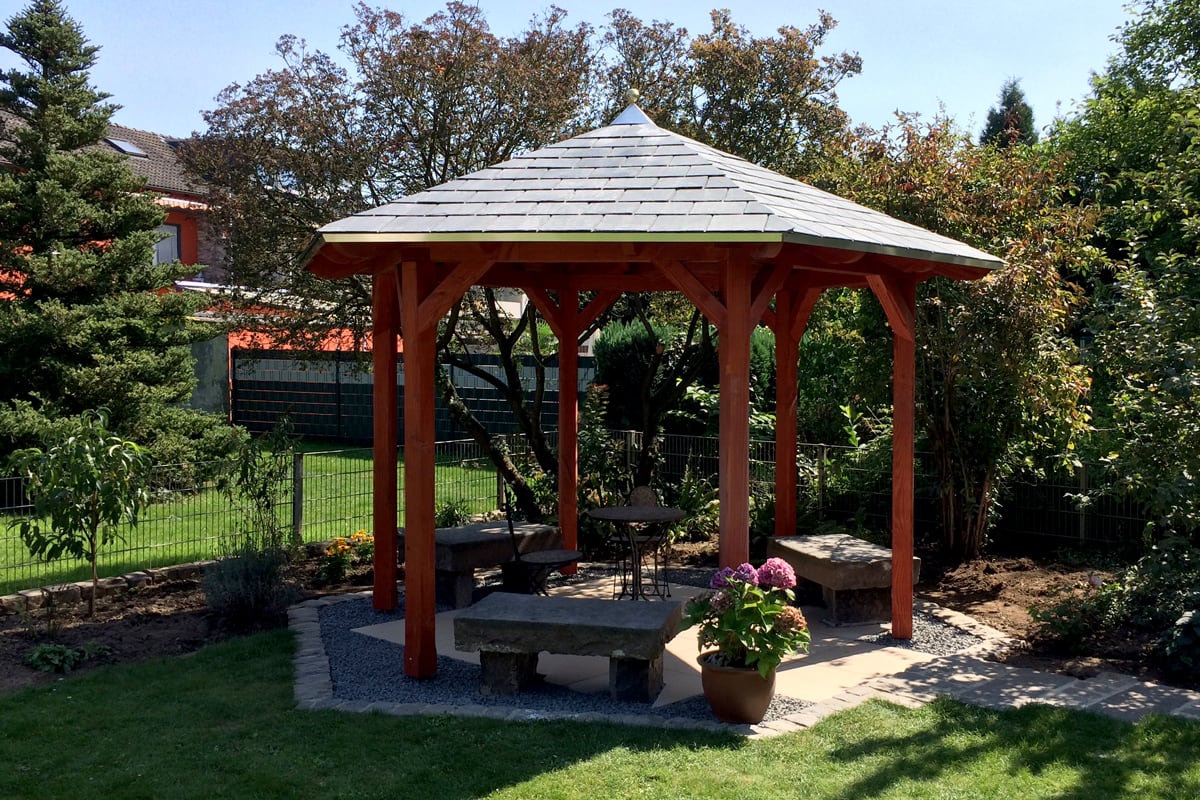 Gartenpavillon aus Holz mit Steinbänken